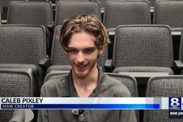 a young man sits in an auditorium speaking to channel eight news