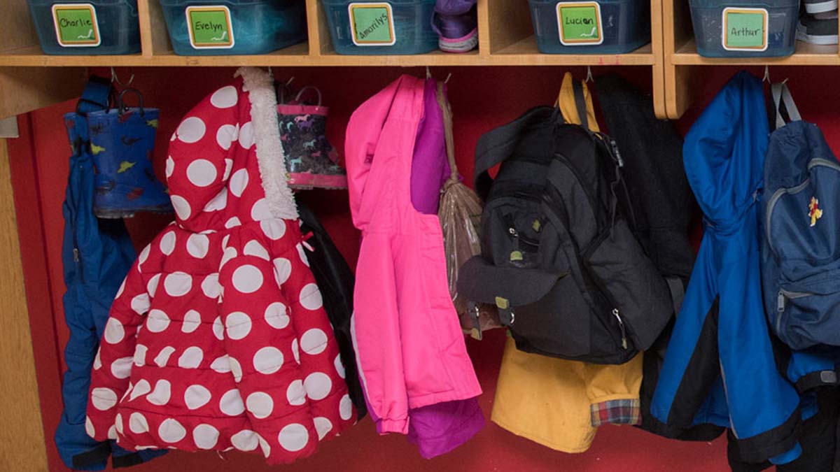Children's coats hanging up in a large closet space.