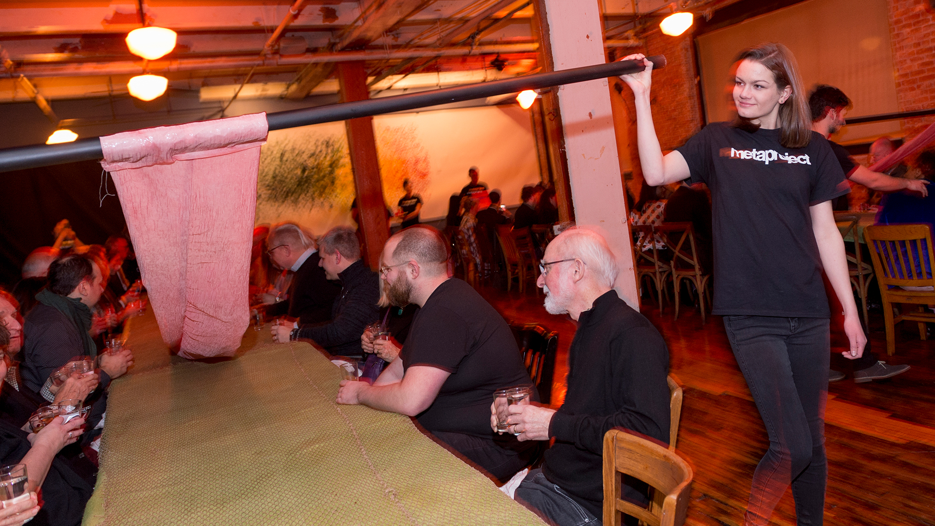 Student walking along table unrolling fabric 