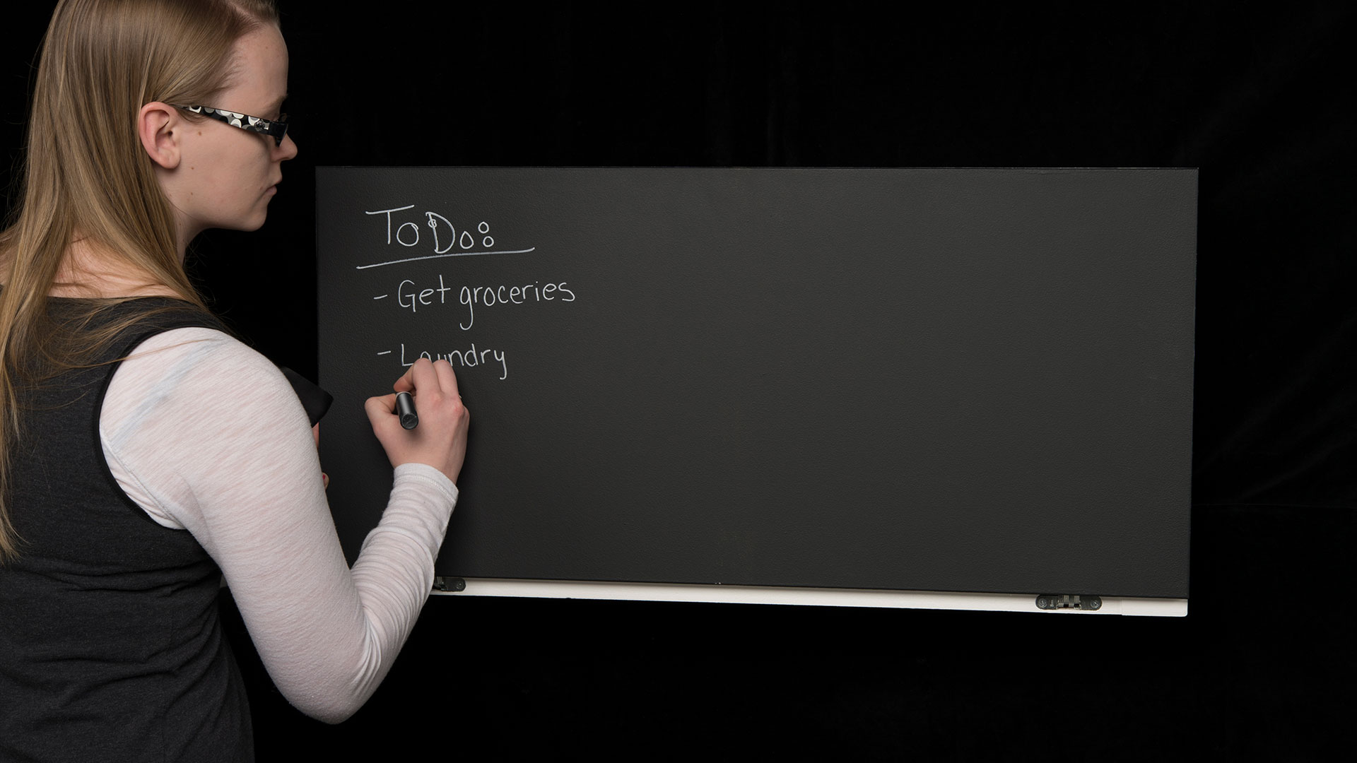 Student writing task list on chalk board surface on closed Kitchen Wall Desk 