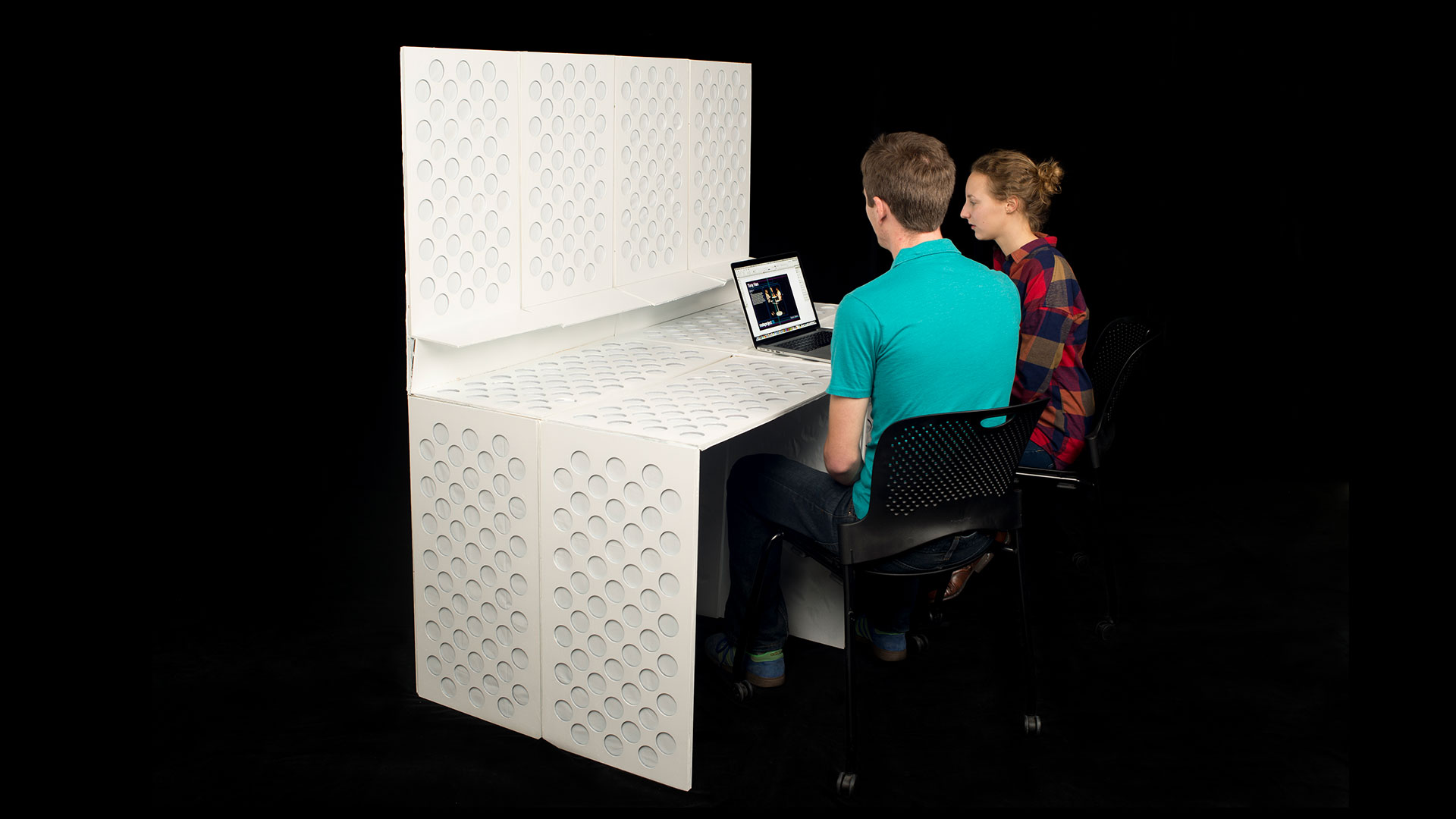 Both students seated on one side of room divider with large portion folded down into mobile desk