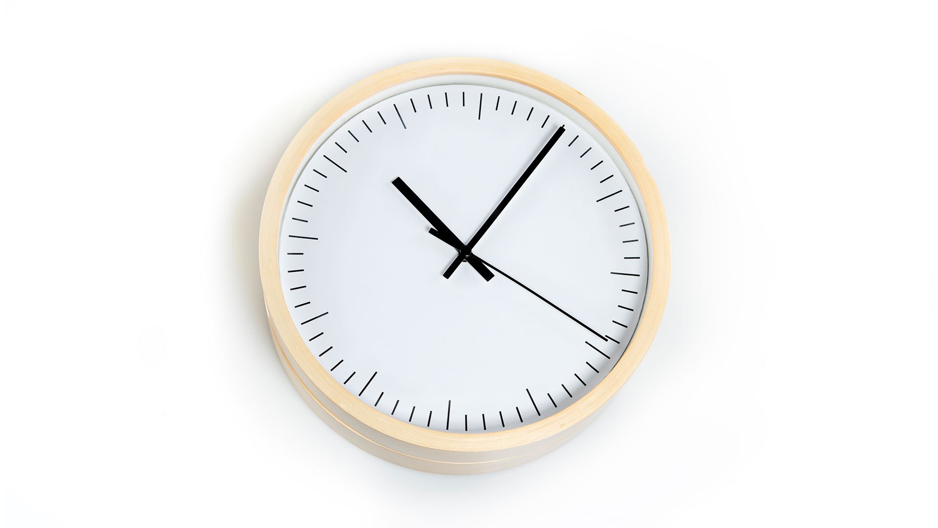 Round analog clock with simple black dash marks in number locations, a minute hand and an hour hand and a second hand, simple light colored wood exterior circle
