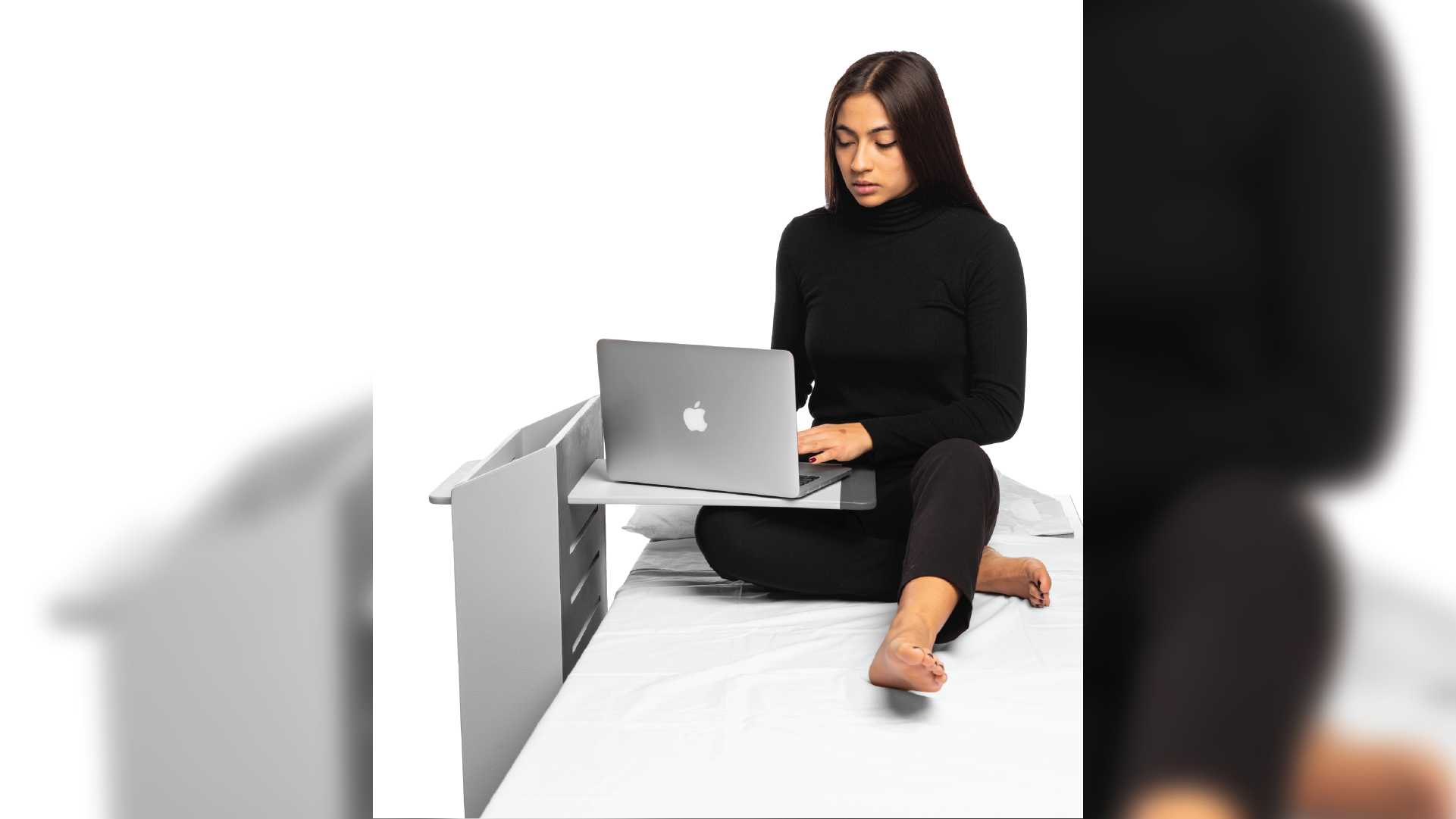 Person using computer on their lap, while sit down on the bed.