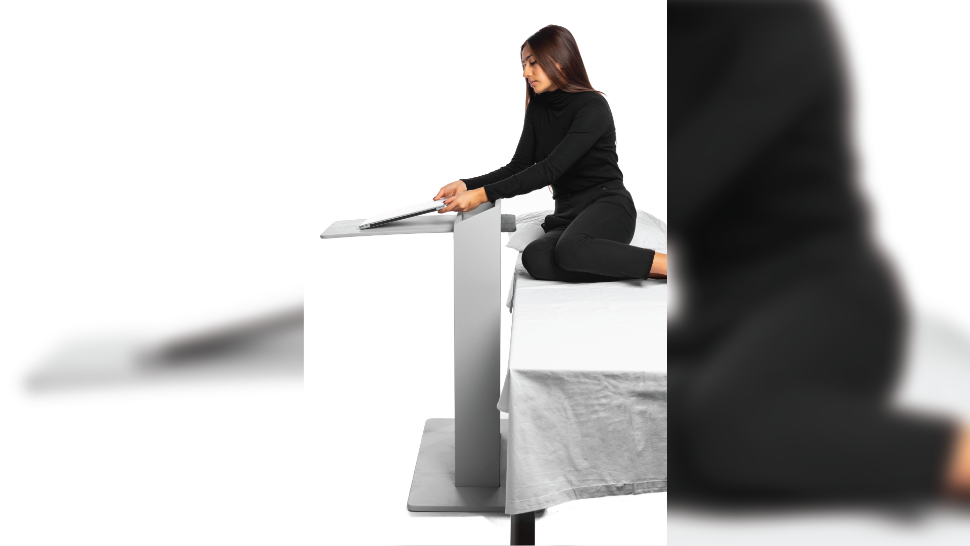 Person placing computer on the convertible bedside.