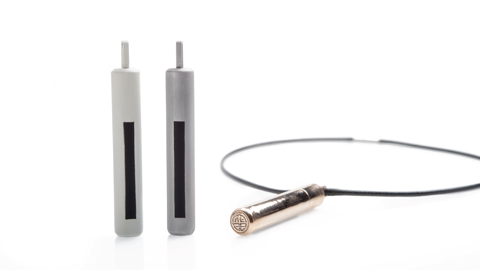 Set of 2 pendants on the left side of the image. A cord with a pendant laid down on the floor is placed on the right side of the image.