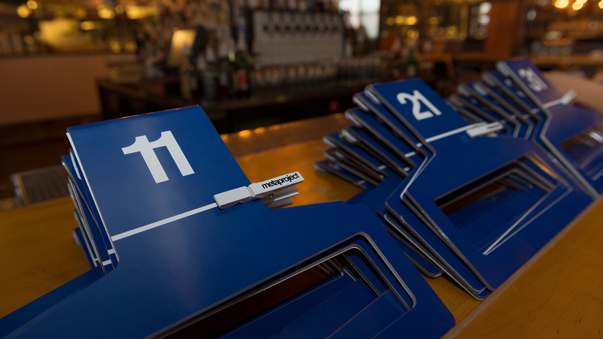 Table with stacked coat hangers designed with numbers on top and loop below with close pin with logo attached 