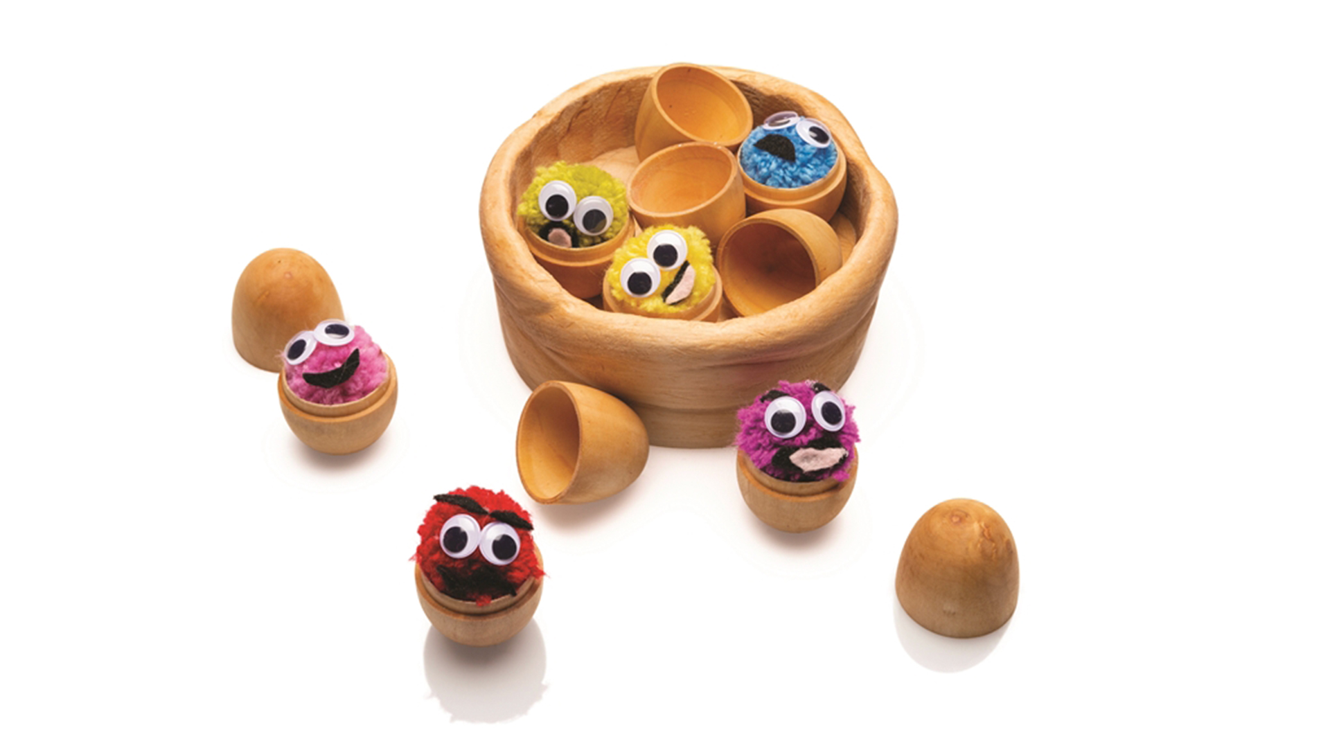 All wooden eggs separated in half showing a colorful ball creature inside each