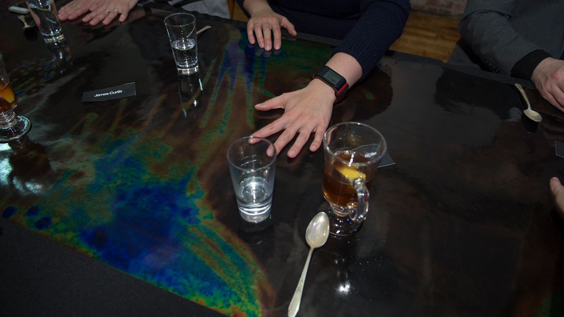 black table showing color changes from temperature changes from drinks and heat from hands