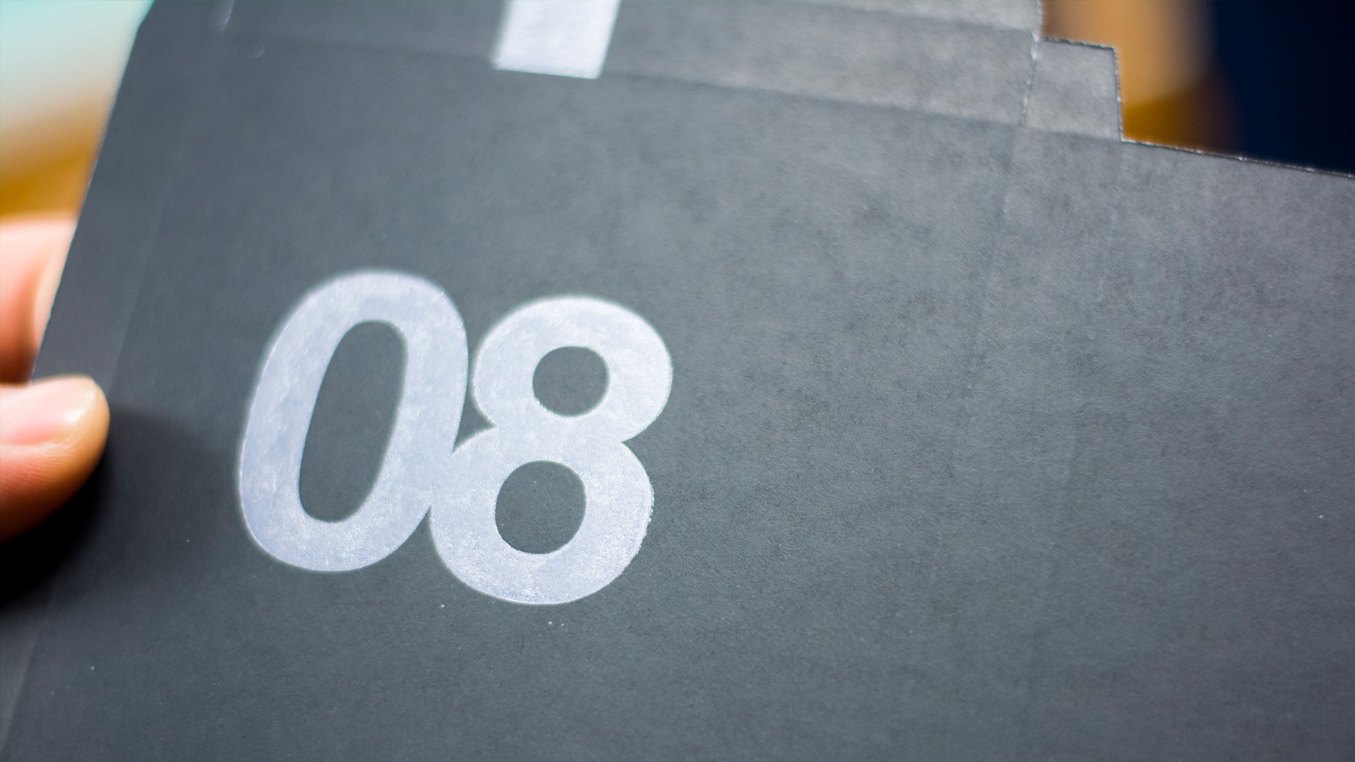 Black card with 08 stamped with white ink 