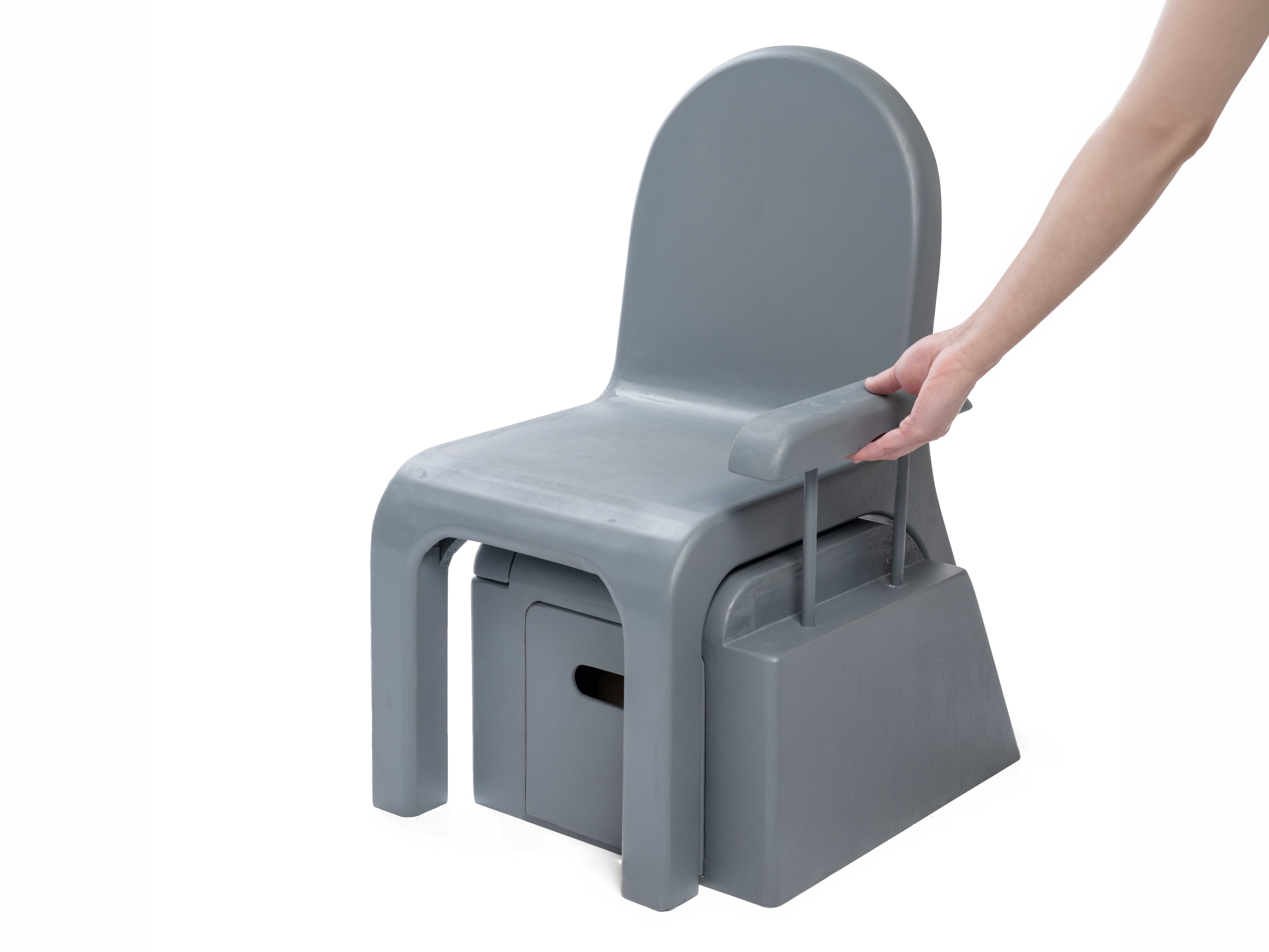 Front perspective view of the Care Chair model with a hand raising the arm rest. 
