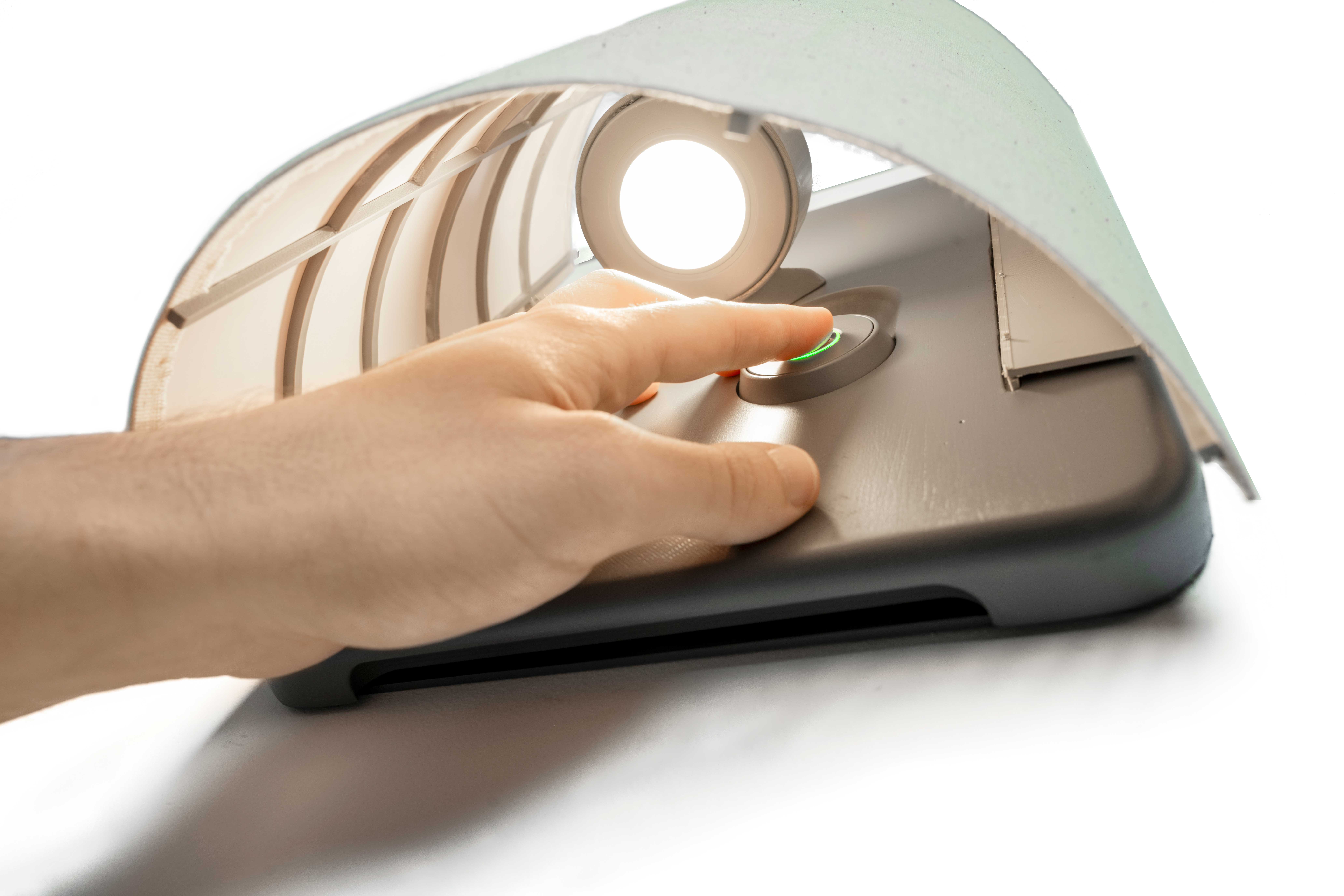 Photo of a hand reaching under the shade of the Illuminated Handgun Safe model to access the finger print scanner that opens the safe.