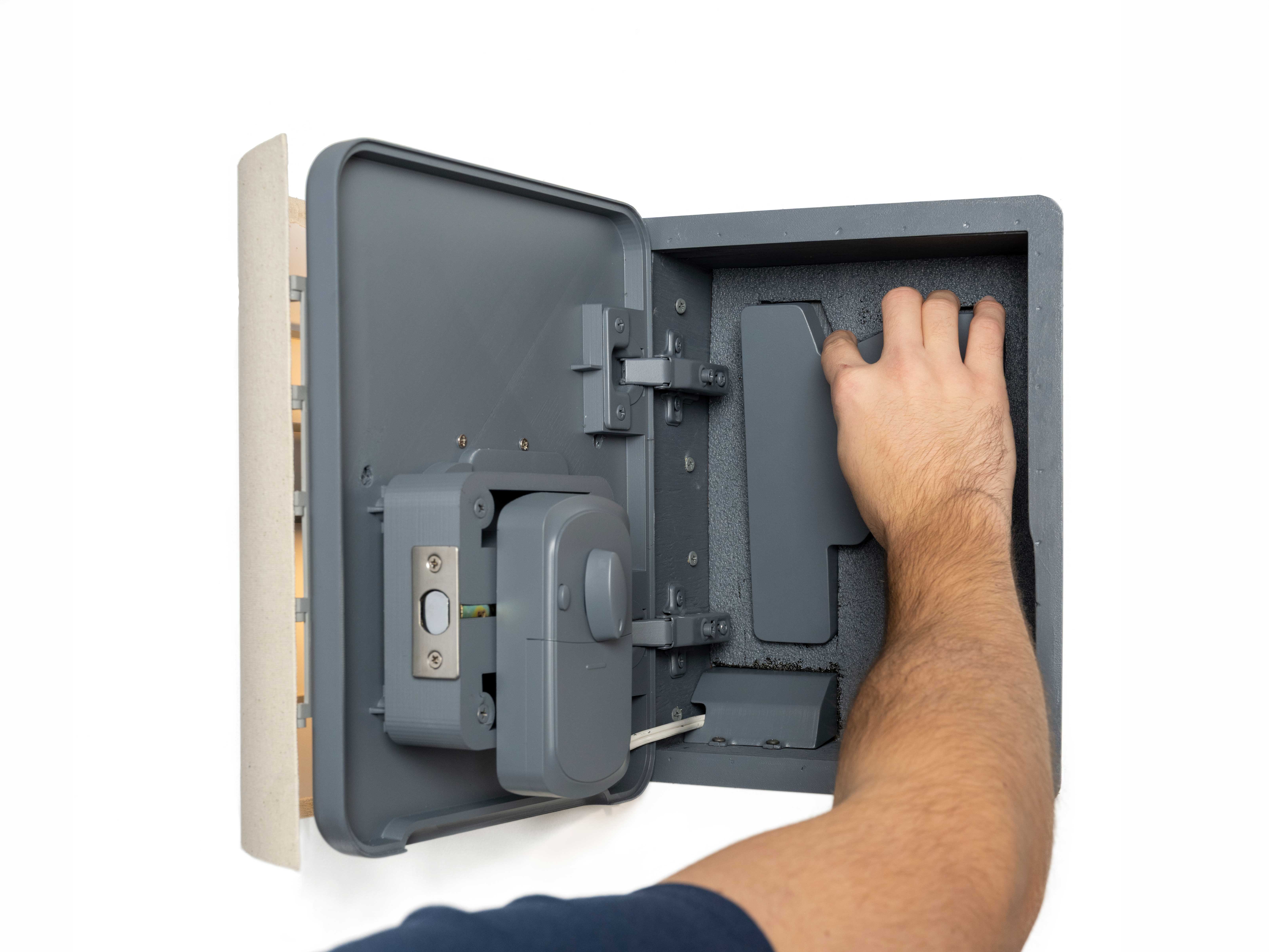 Photo of a hand reaching into the open Illuminated Handgun Safe model to get the model of the hand gun.