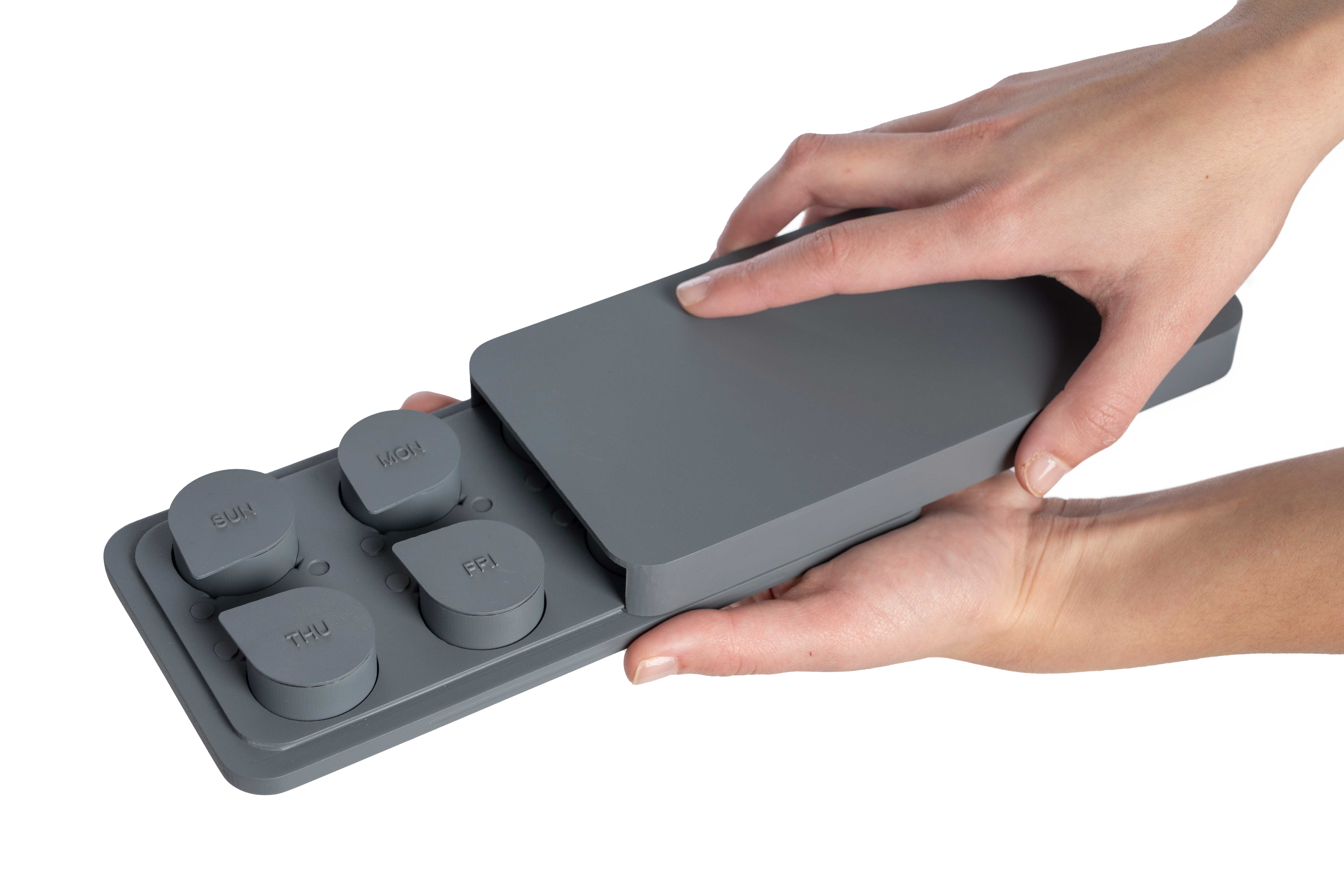 Photo of a hand holding and opening a tray from the Sorted Medicine Cabinet model.