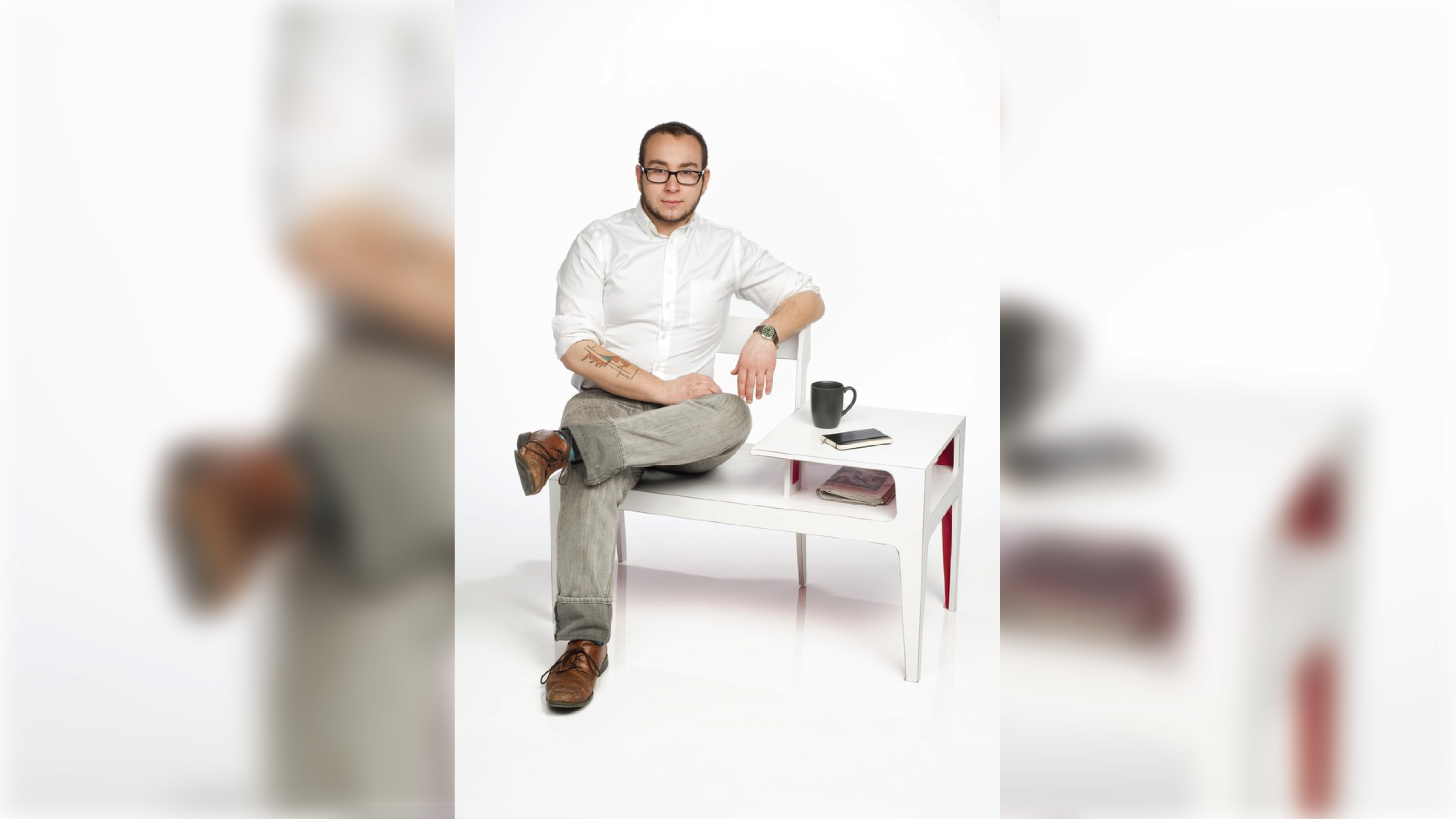 Person sitting on a bench that has two seats and an occasional table.