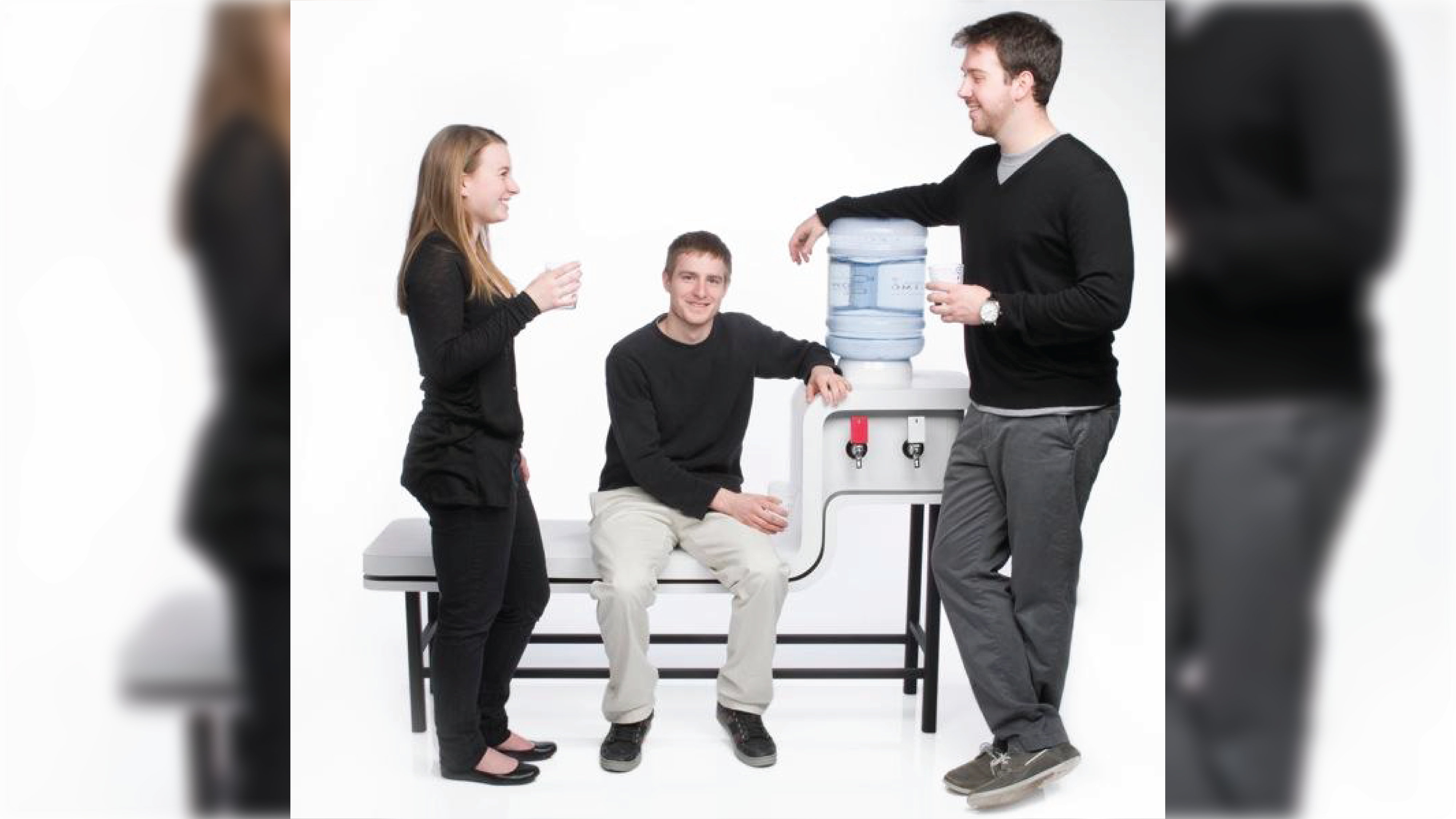 A bench with a built in water cooler and people interacting around the furniture.