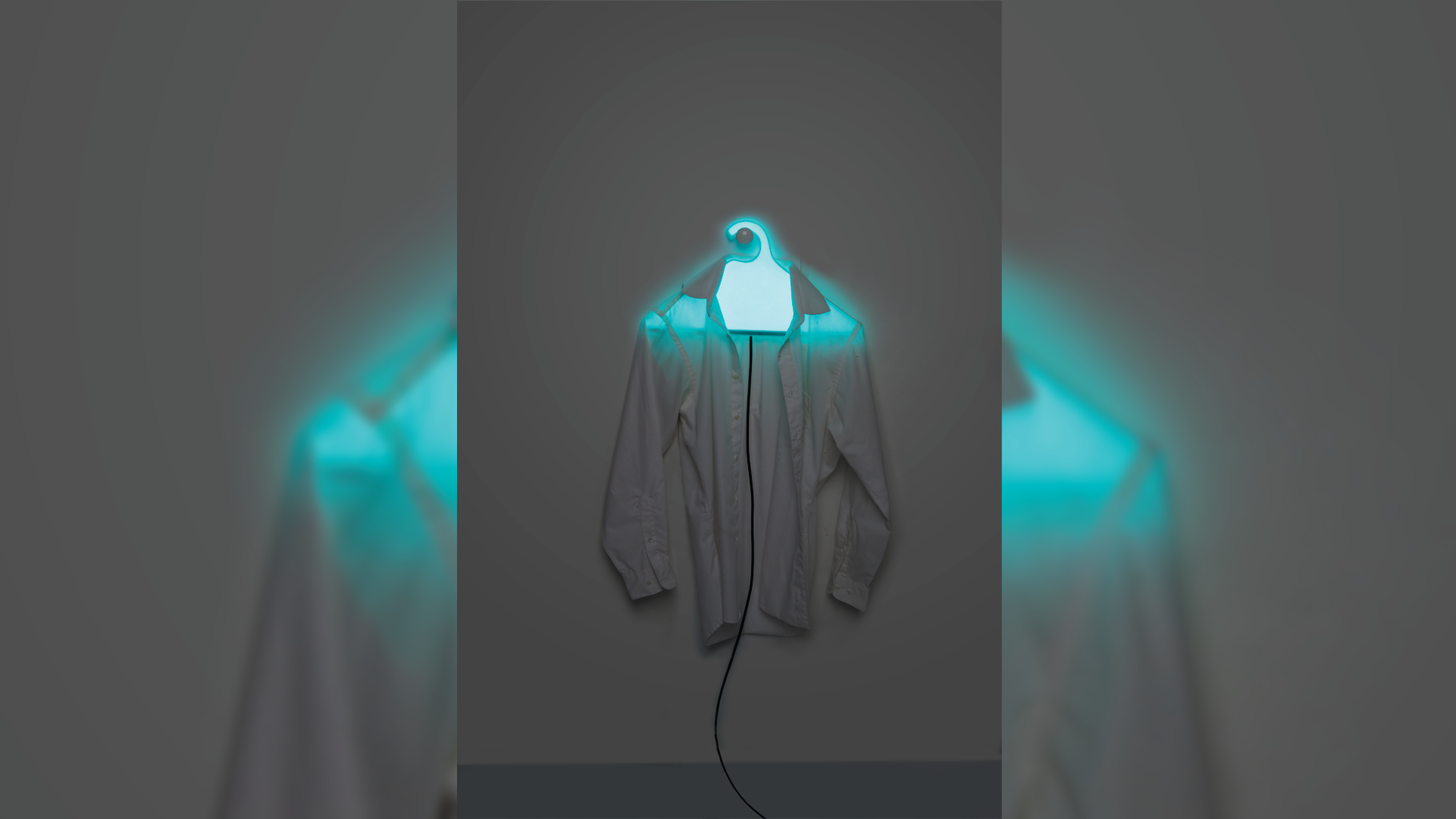 Clothes hanger with integrated light source holding a white shirt.