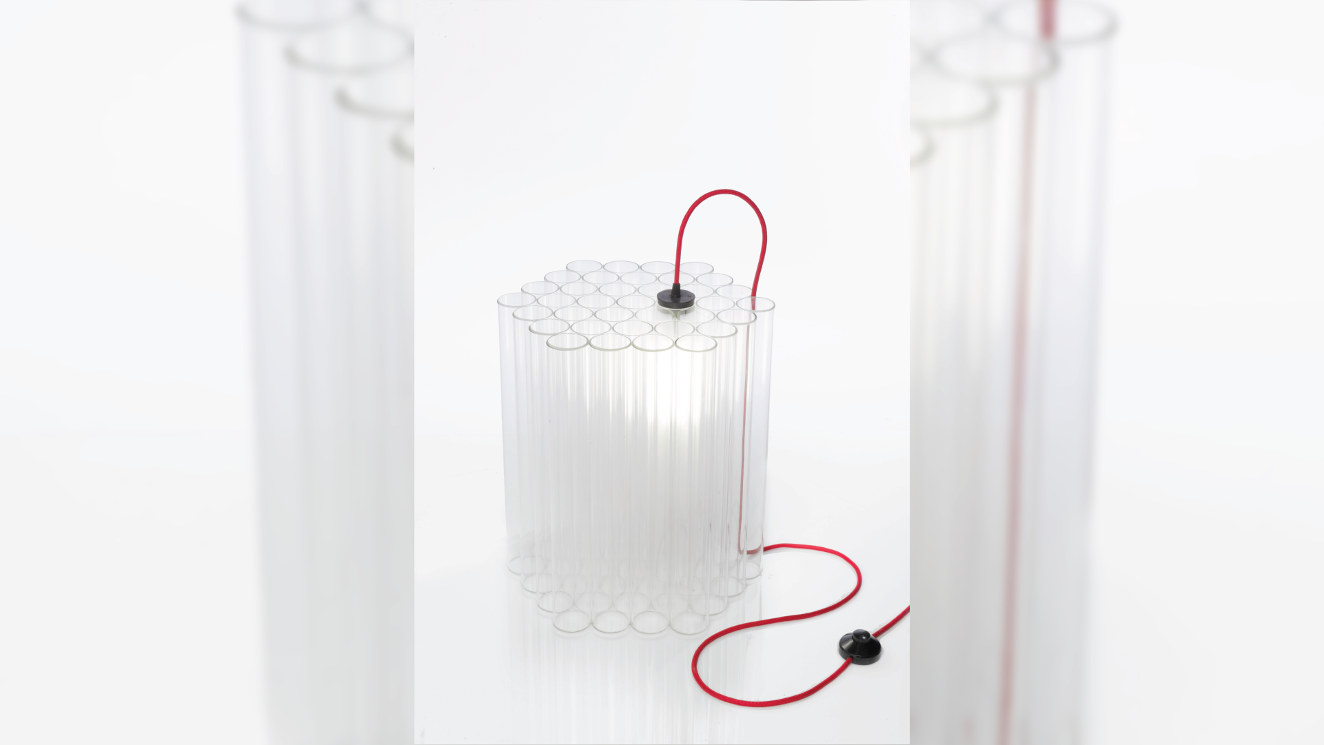 A side table made with glass tubes that is illuminated by a light inserted in one of the tubes.