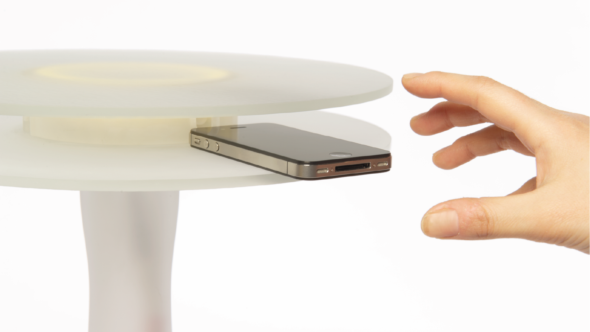 Detail shot of the side table holding a phone in between the two disks