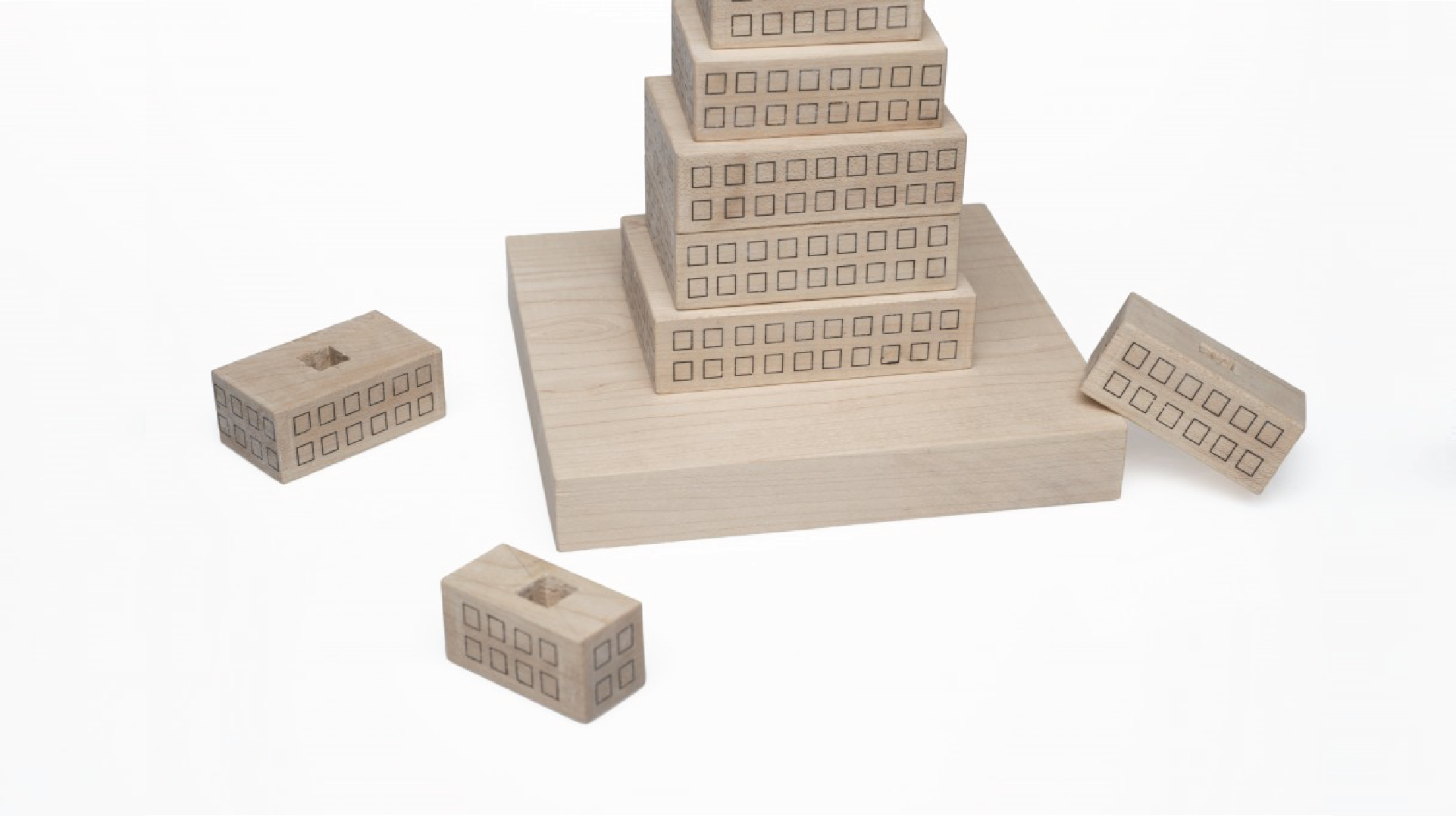Detail shot of the base of the stacking toy with 3 wood blocks placed on the floor.