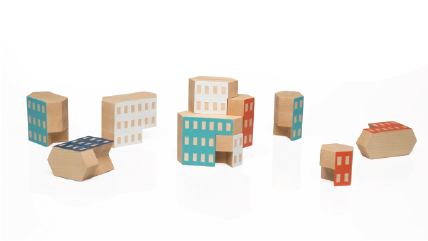 Set of wooden blocks in the shape of buildings stacked to form different constructions. Some blocks have natural wood finishing and others are painted in different colors.