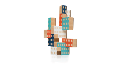 Set of wooden blocks in the shape of buildings stacked to form constructions. Some blocks have natural wood finishing and others are painted in different colors.
