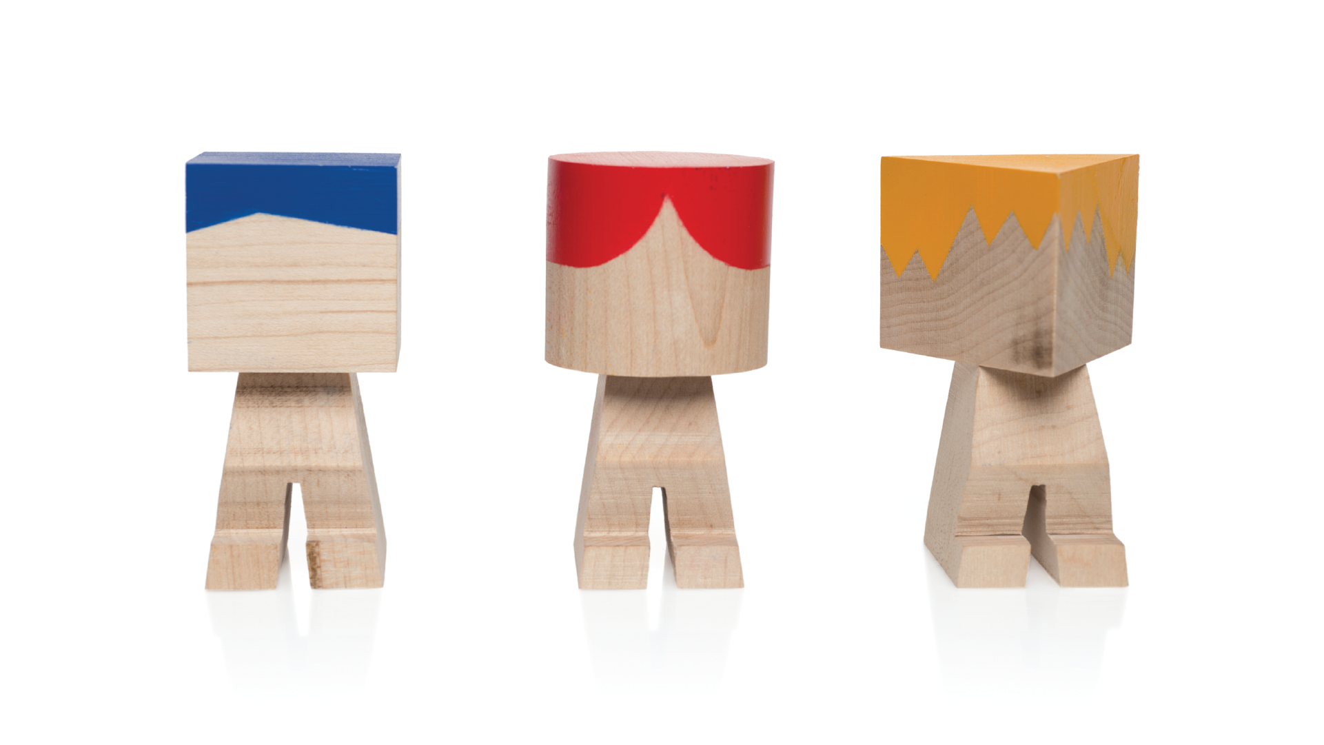 three wooden mini figures with different body shapes. From left to right, blue square, Red cylinder, Yellow triangle.