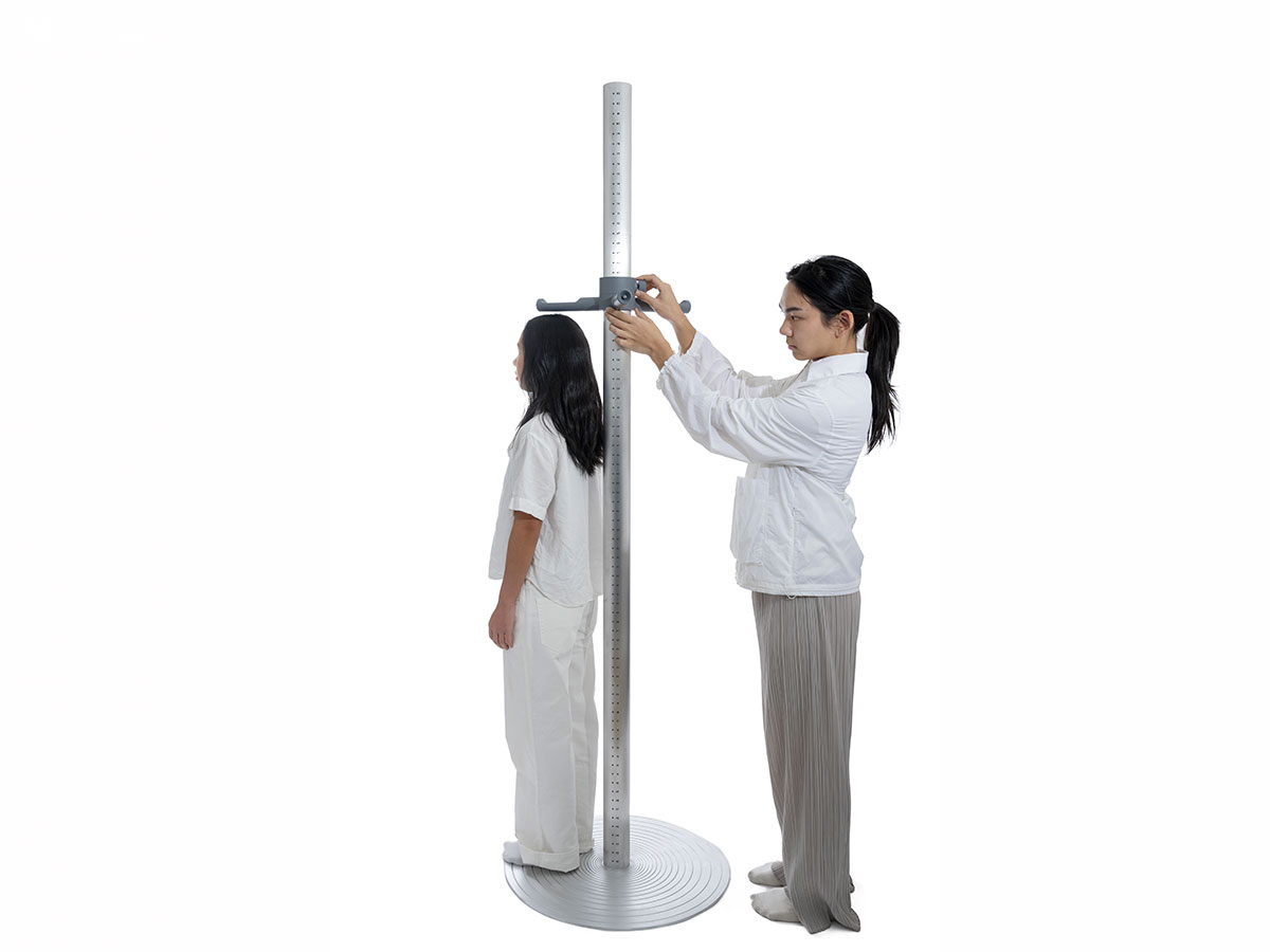 Photo of Strata model being used to messure the height of women. 