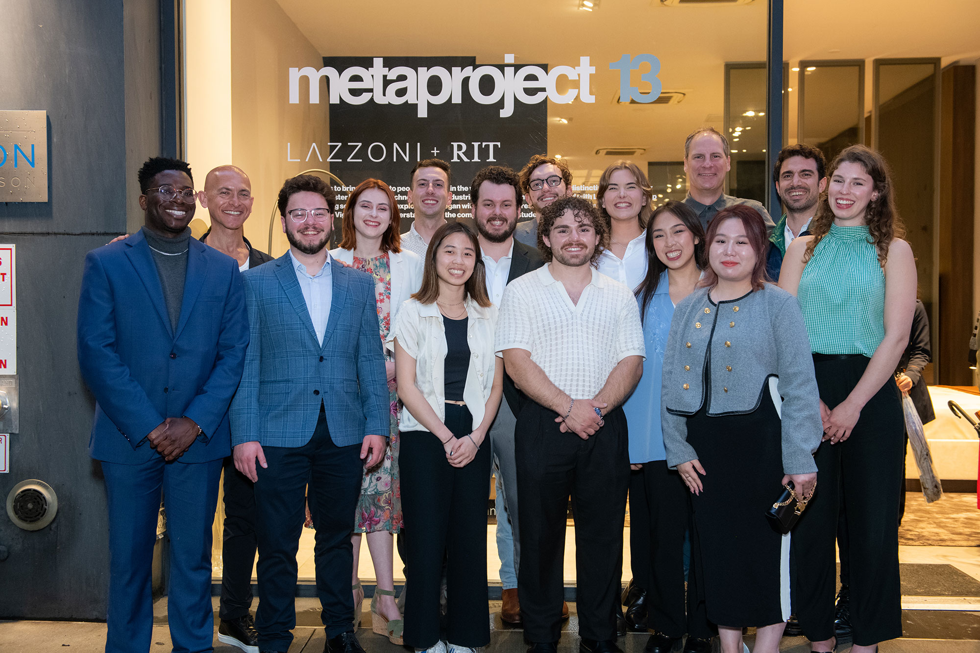 a group of people standing in front of a glass window that says metaproject 13