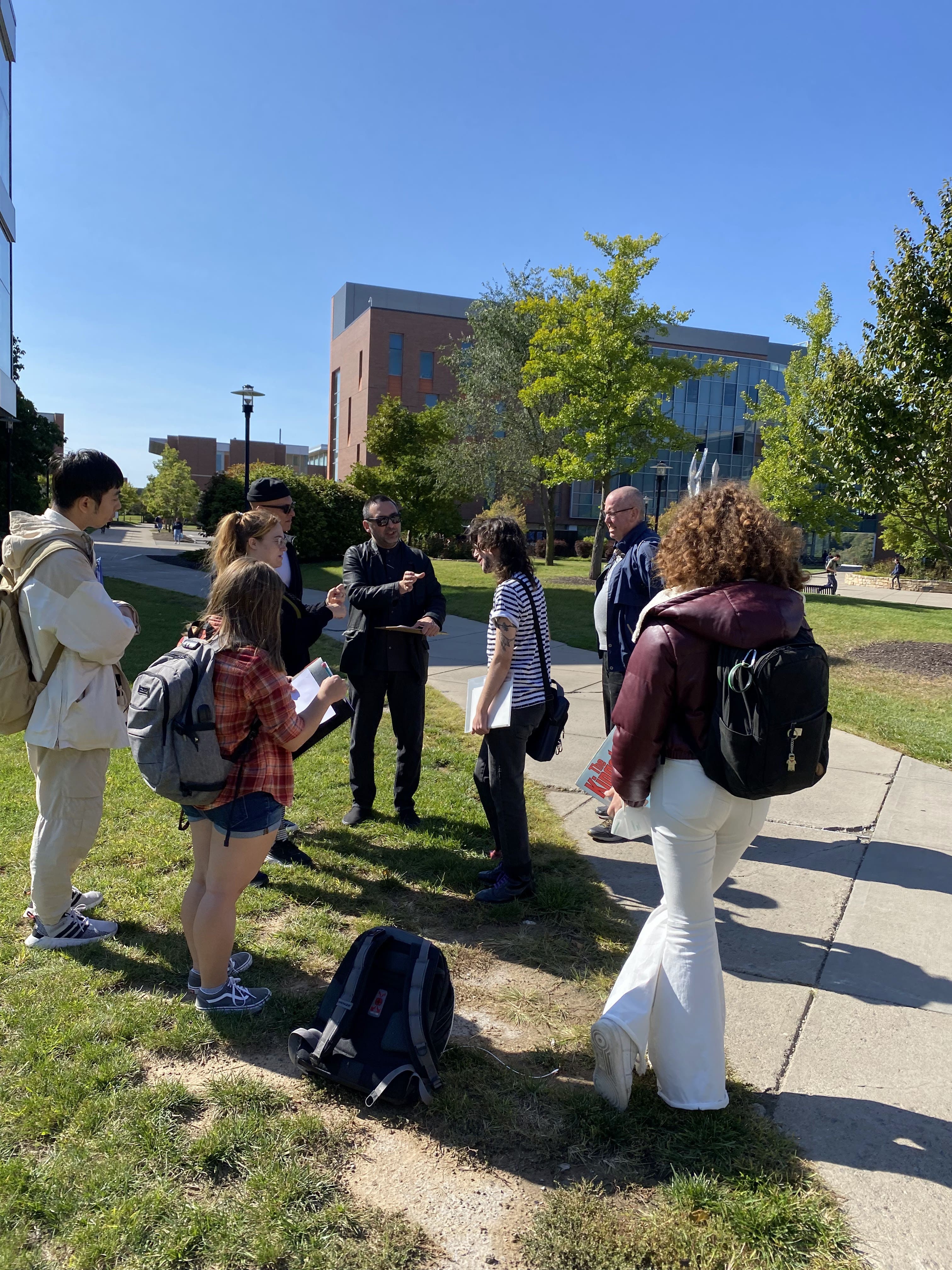 Students and Professors discussing outdoors on campus.