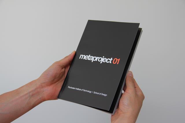 A person holds the Metaproject 01 book.