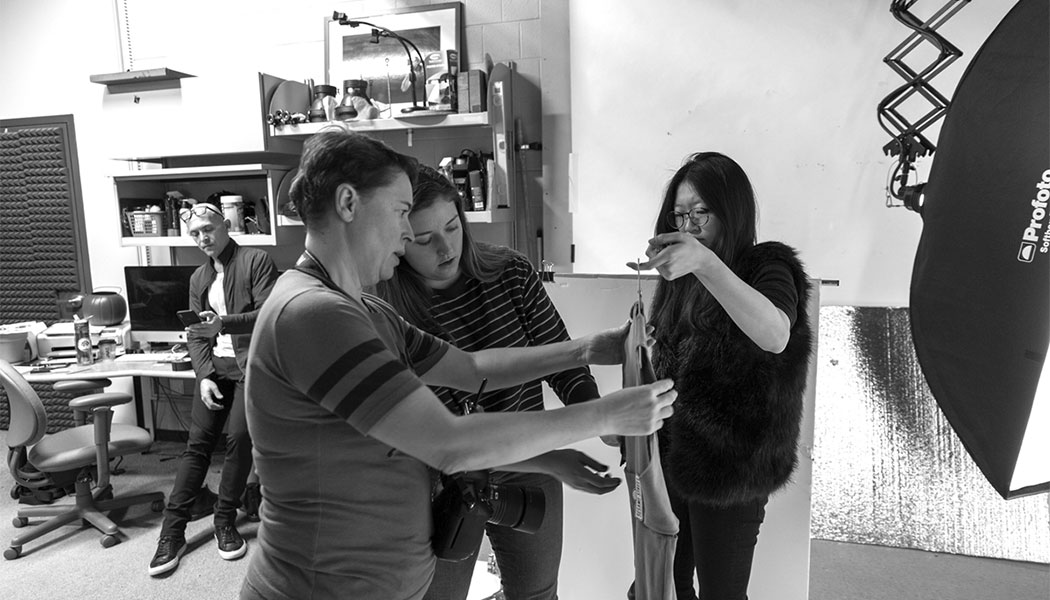 a black and white photo of students preparing to have projects photographed