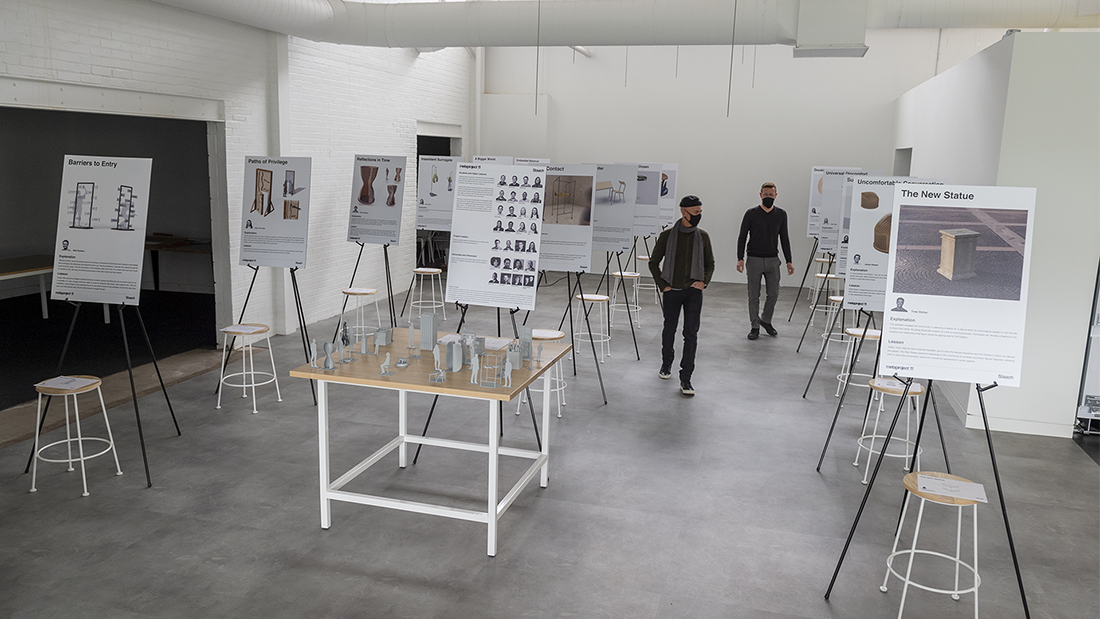 Two people walking around the student posters placed at Staach.