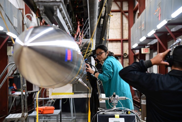 researcher making adjustments to a rocket.