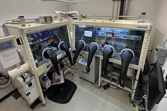 lab equipment with sensitive materials in glass cases accessible with large rubber gloves attached to the glass.