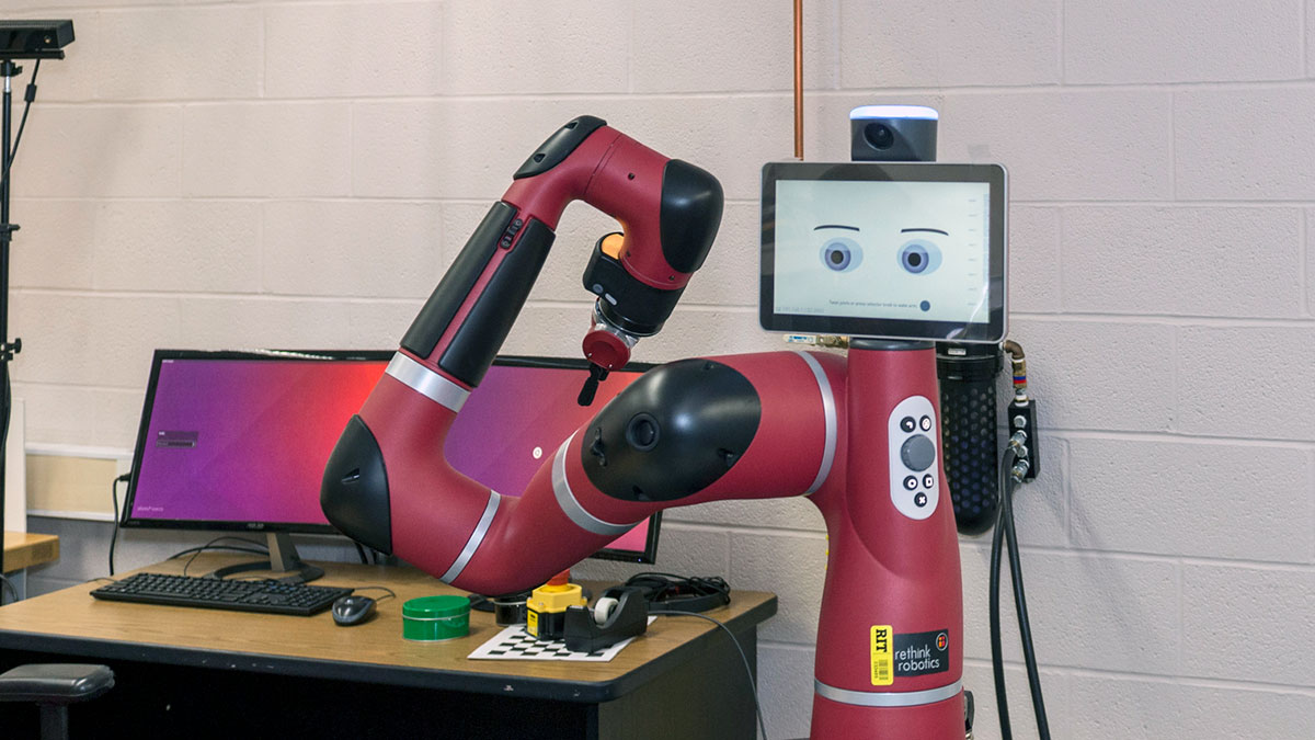 a robotic arm with a screen that has a cartoon face.