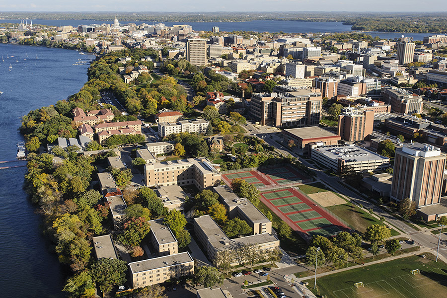 buildings and tennis courts surrounded by a body of water