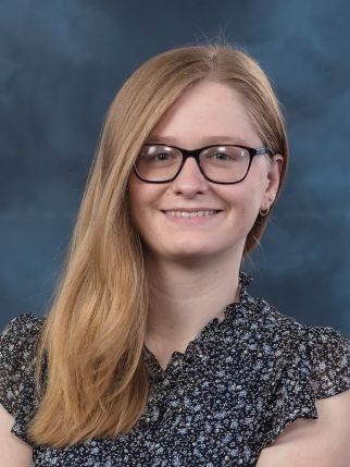 A woman with blonde hair and glasses smiling