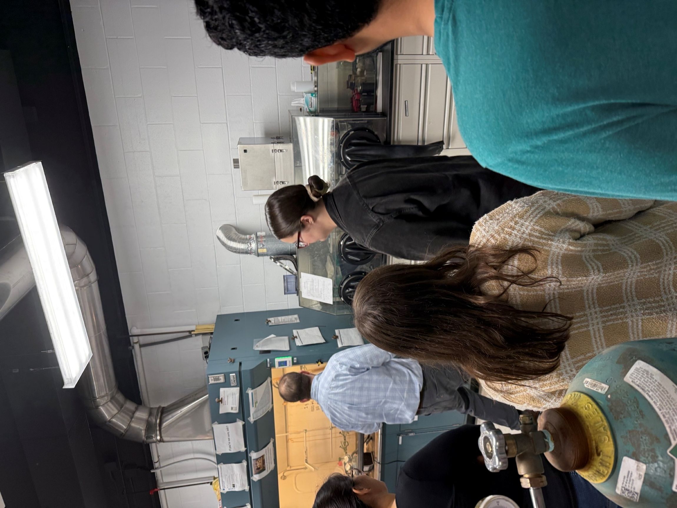 Professor Polly demonstrating use of the glove box in NPRL lab to trainees