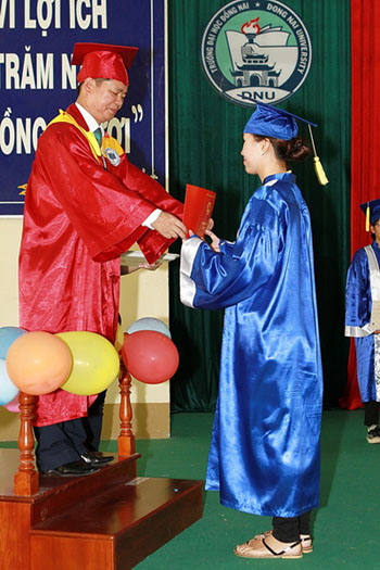 Dr Thanh Pham, Vice-president of Dong Nai university, presents the diploma to a student.