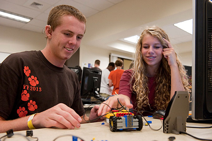 pair of students male and female working on robot
