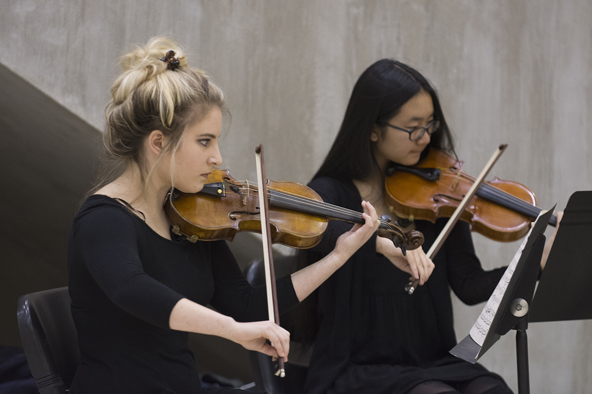 Two women playing violin at a Dyer Arts event