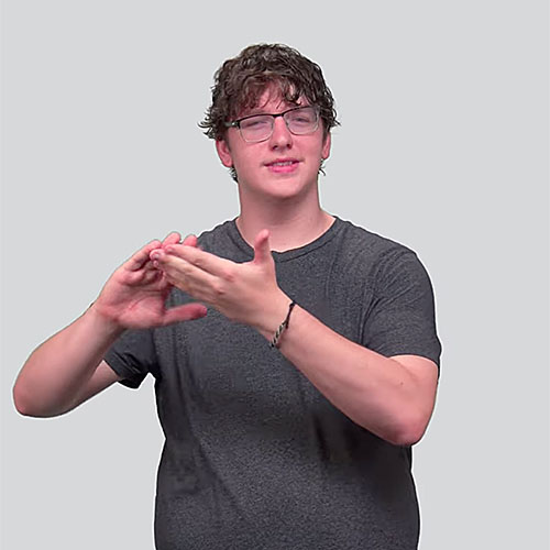 Person wearing a dark gray t-shirt demonstrating the American Sign Language sign for 'community.'