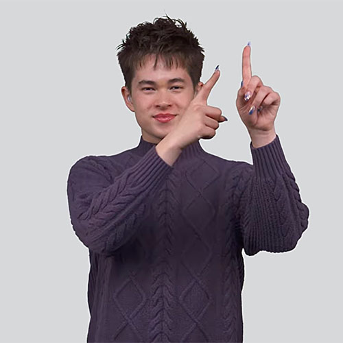 Person wearing a textured sweater, standing with both hands raised and pointing upward.