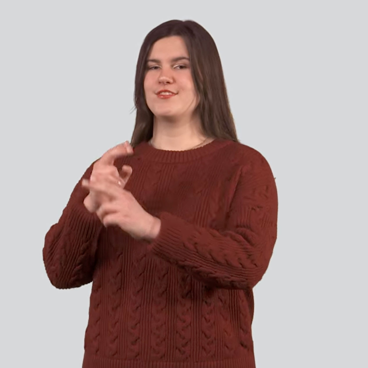 Person wearing a textured rust-colored sweater, using both hands to sign 'honor'.