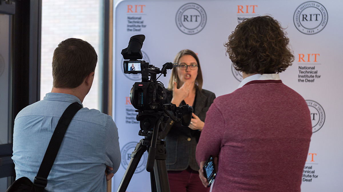A videographer and writer interviewing an alumna