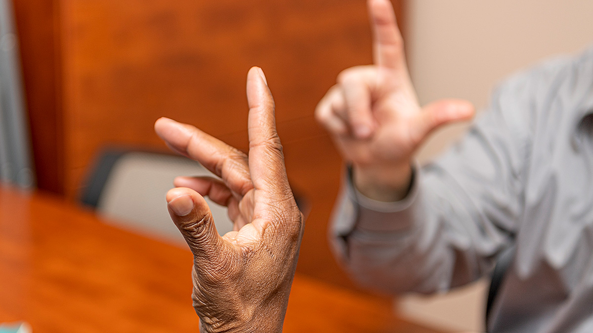 Close-up photo of hands signing during a tutoring session