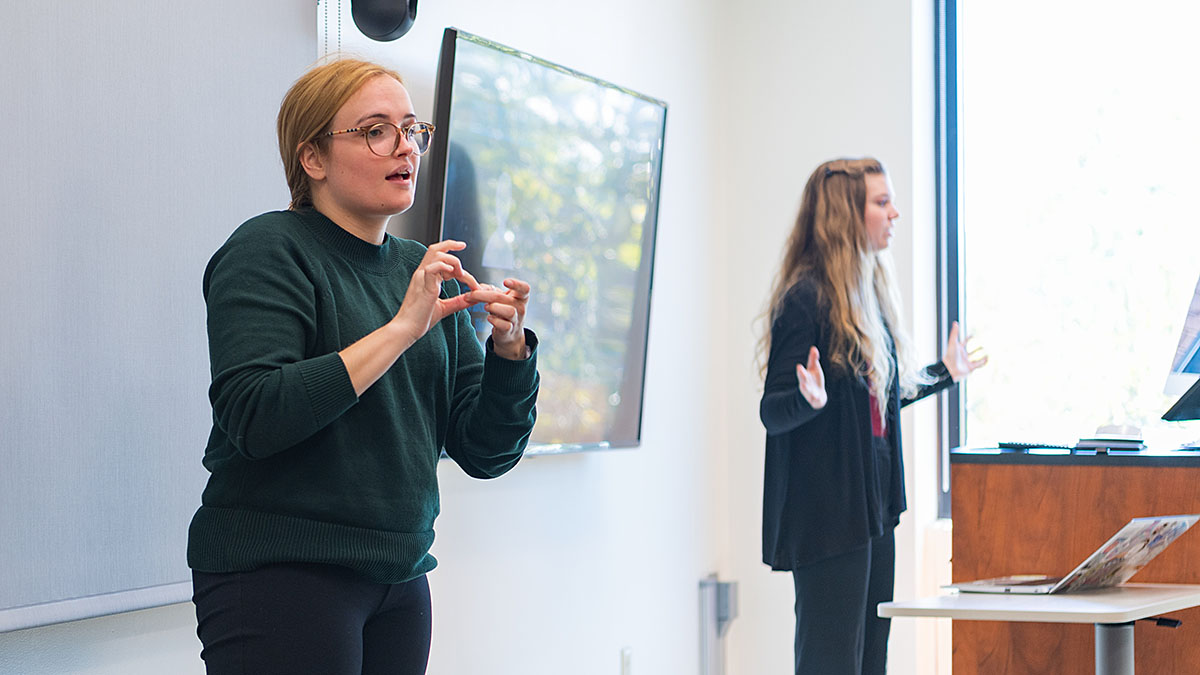 Two students teaching and interpreting for class