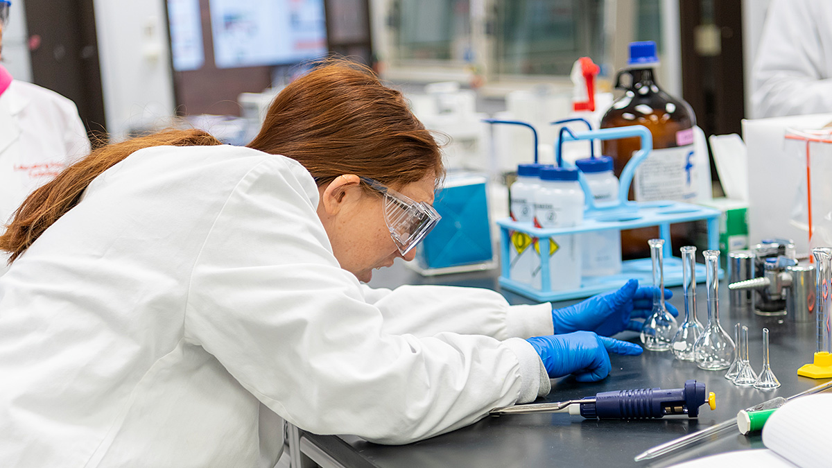 Student looking at glass beakers in a science laboratory