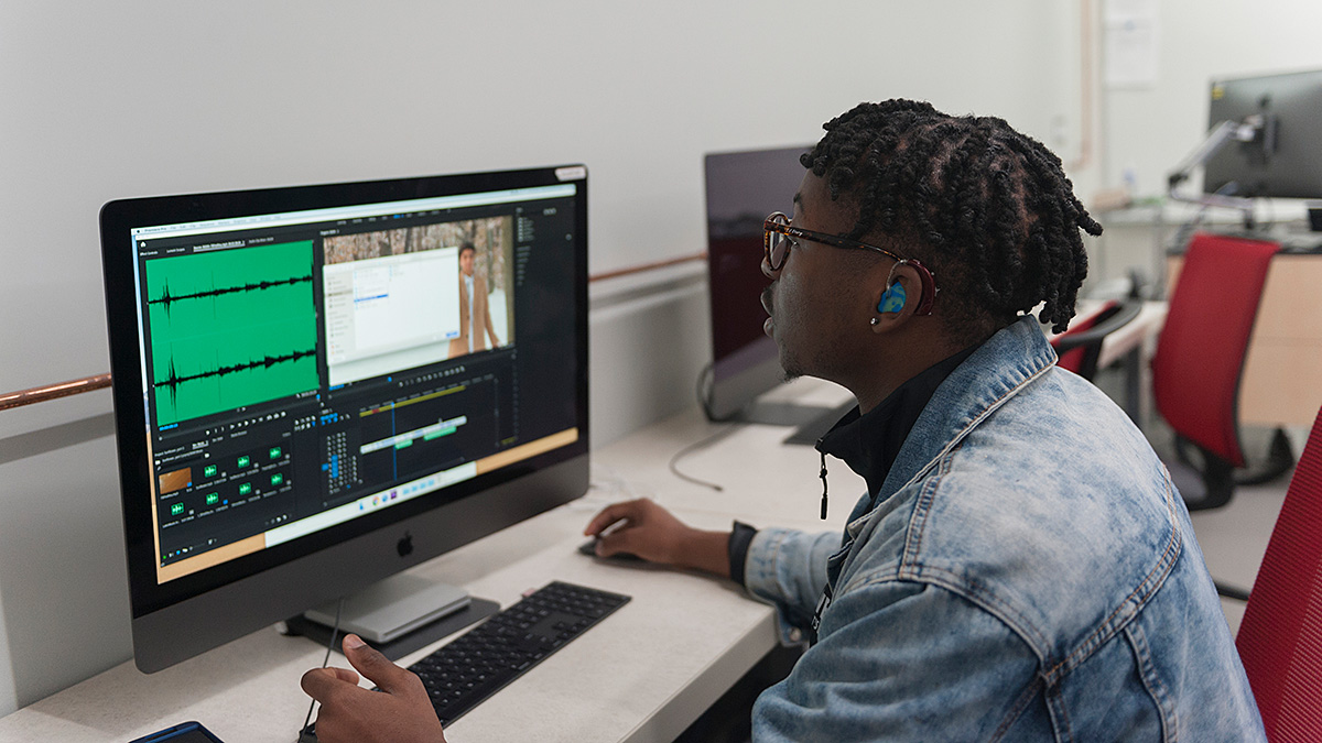 A student edits video in a computer lab.