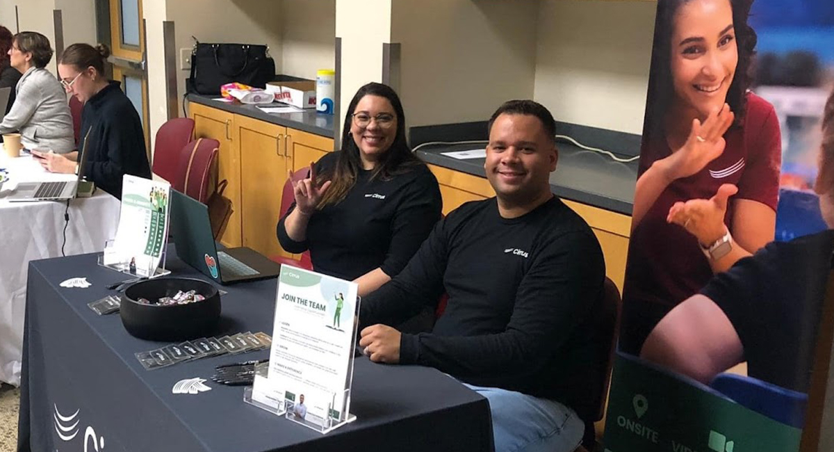 People conversing with and signing with career fair agencies